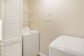 a laundry room with a washer and dryer and a closet at The Oliver Apartment Homes, Mississippi
